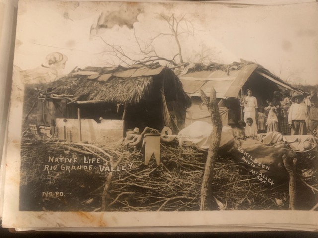 A historical photo showing a family outside a rustic home