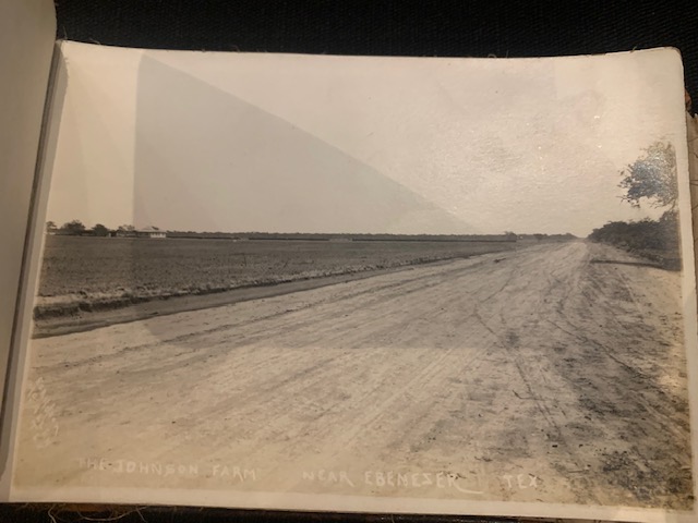 A wide landscape showing the Johnson Farm near Ebenezer, Texas, with a long dirt road in the foreground.